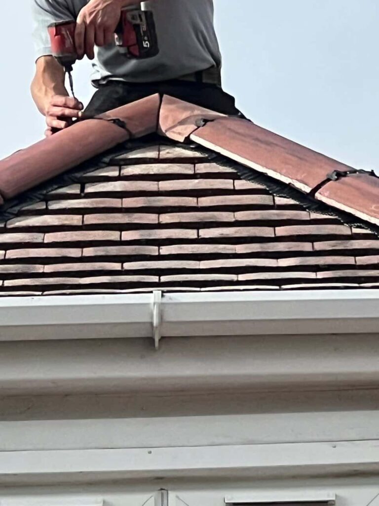 This is a photo of one of the operatives of TRP Roofing Withernsea installing new ridge tiles