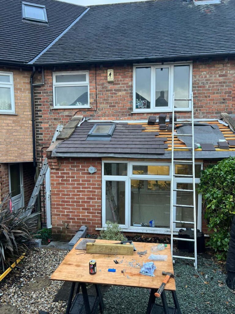This is a photo of a roof extension that is having new roof tiles installed. This is a photo taken from the roof ridge looking down a tiled pitched roof on to a flat roof. Works carried out by TRP Roofing Withernsea